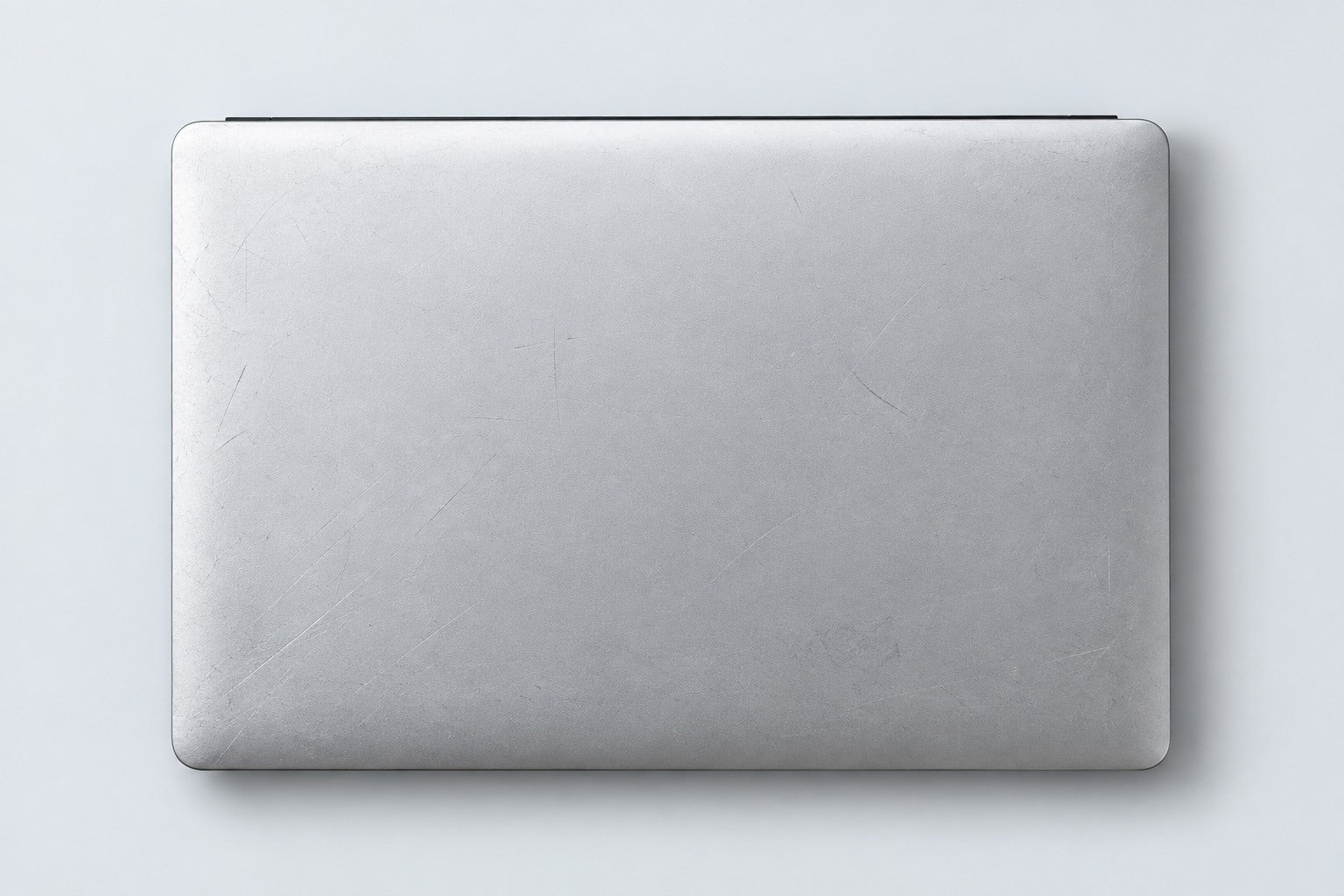 Before: a silver laptop lid with visible surface scratches